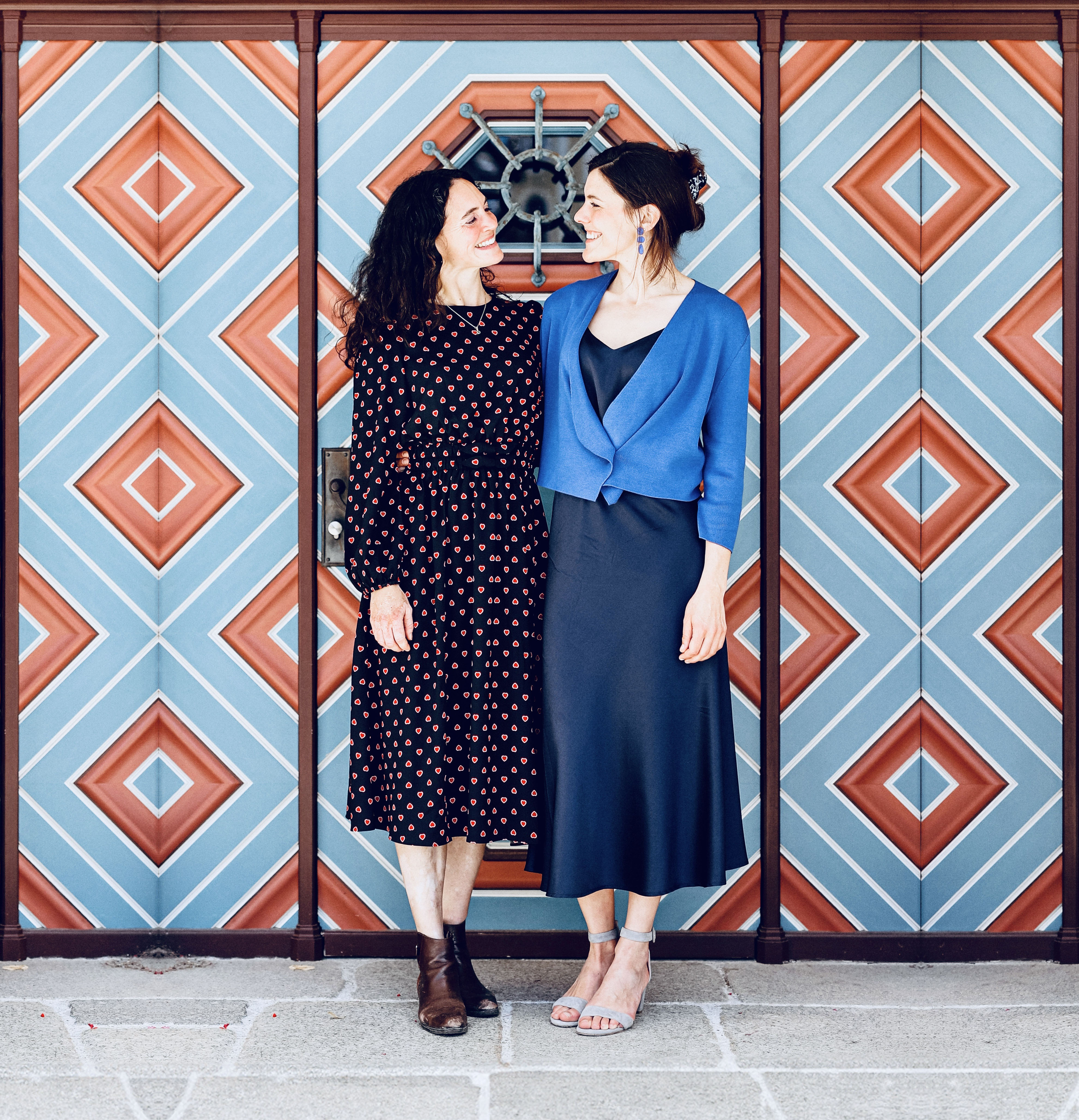 Duo Velvety mit Tessa Catchpole und Lucia Holzer steht vor einer blau-roten Wand.