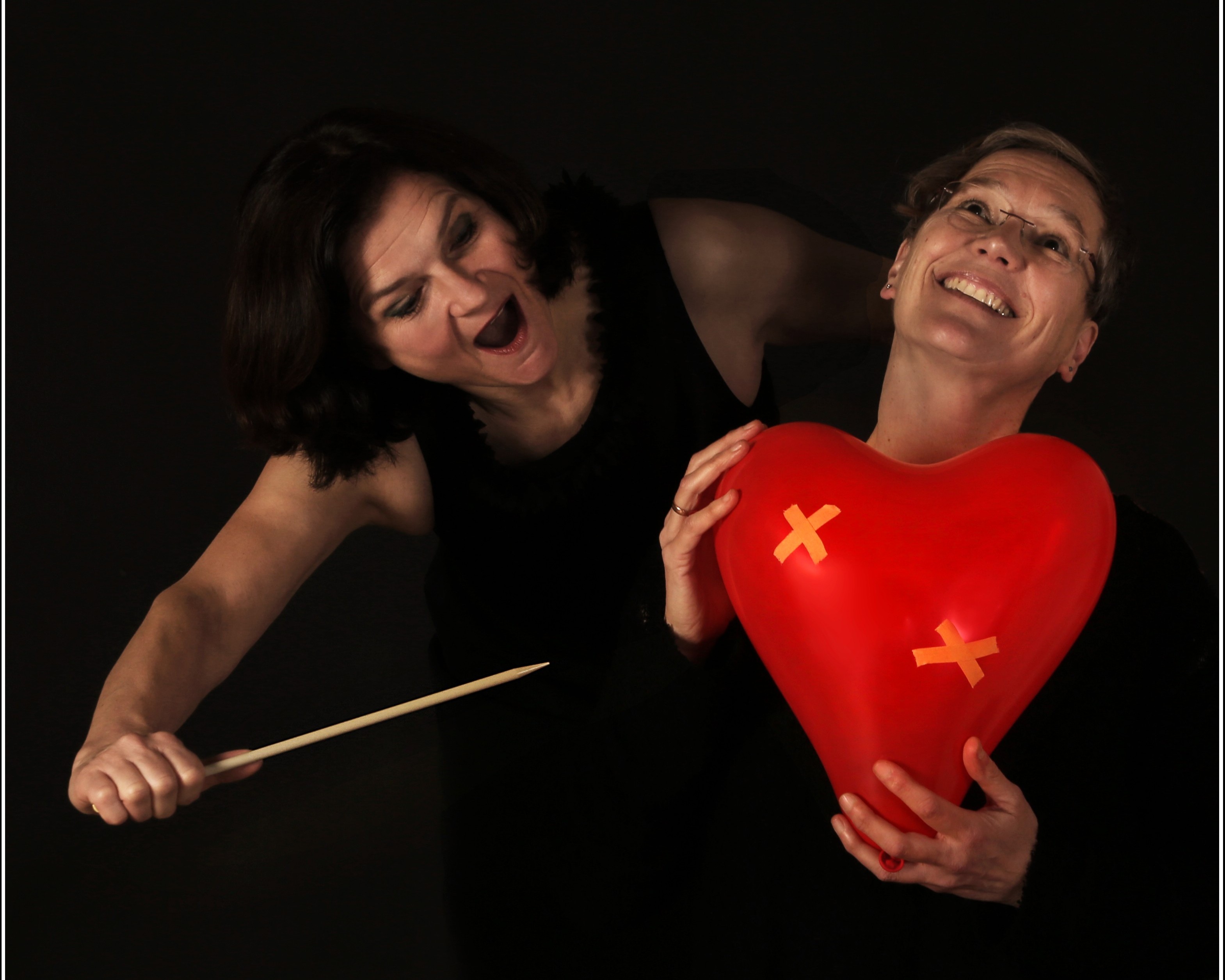Friederike Duetsch und Maria Bittel (c) S. Niederbuchner Friederike Duetsch und Maria Bittel mit roten Herz Luftballon und einer großen Nadel in der Hand